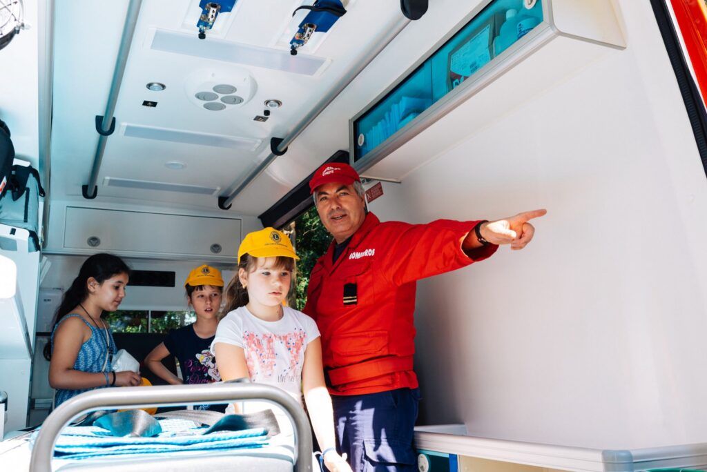 Ein Feuerwehrmann zeigt Kindern in Porto das Innere des Rettungsautos