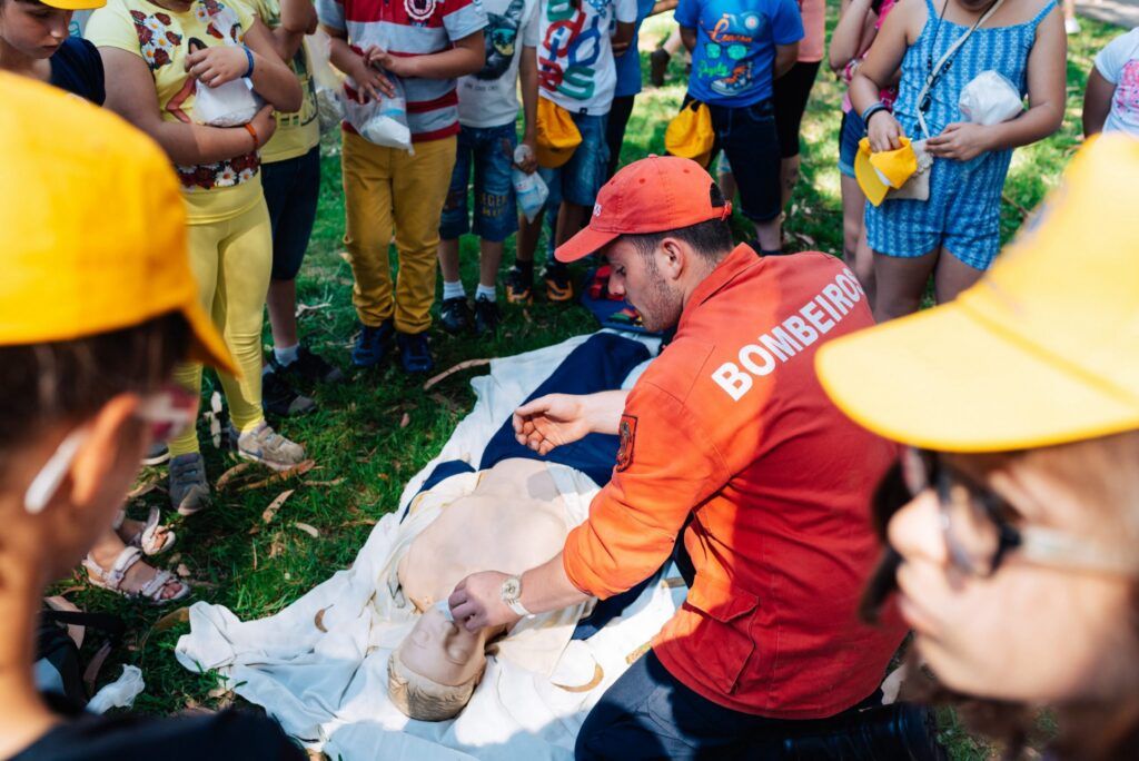 Feuerwehrmann zeigt Kindern in Porto die Wiederbelebung an einer Übungspuppe